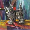 Still life of grey cat statuette on multi-coloured fabric